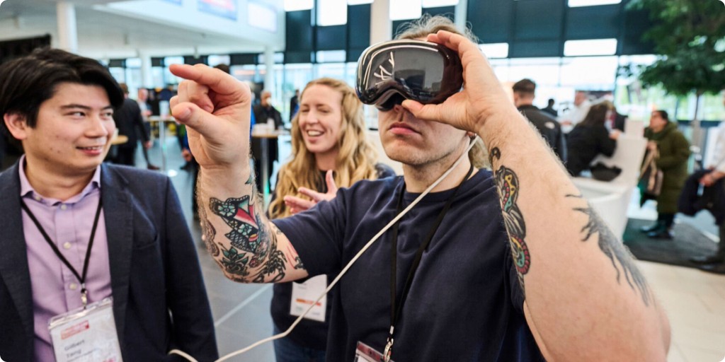 Demonstration of spatial storytelling — guest wearing Apple Vision Pro with observers in a bright event space