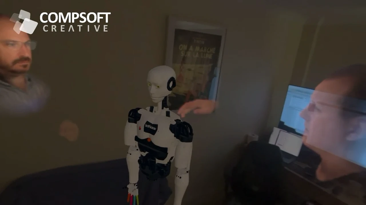 Two people appearing together in a STAGEit SharePlay session, with a robot model between them